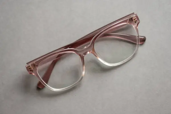 グレーの背景にピンクのメガネ ロイヤリティフリーのストック画像