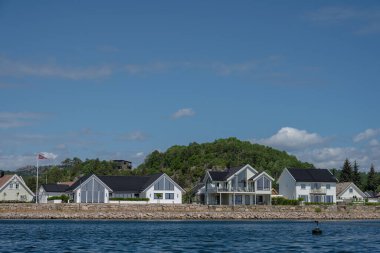 Lindesnes, Norveç - 22 Haziran 2023: Kanal kenarında büyük beyaz villalar.