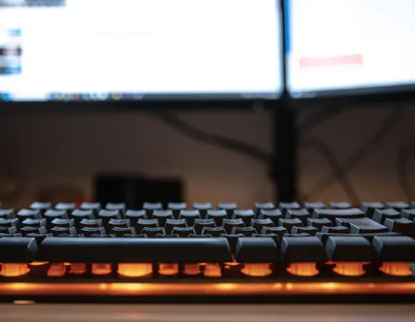 Πληκτρολόγιο Υπολογιστή Πορτοκαλί Φώτα Μπροστά Από Οθόνες Computewr — Φωτογραφία Αρχείου