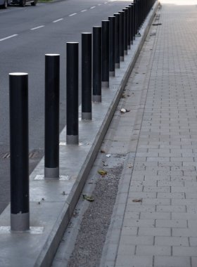 Bir bina ve kaldırımı koruyan metal direkler..