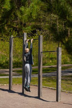 Göteborg, İsveç - 07 Mayıs 2023: Metal barlara asılan çocuk.