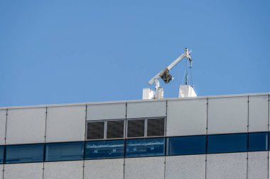 Cam temizleyicisi yüksek bir binanın çatısında iyon kaldırıyor..