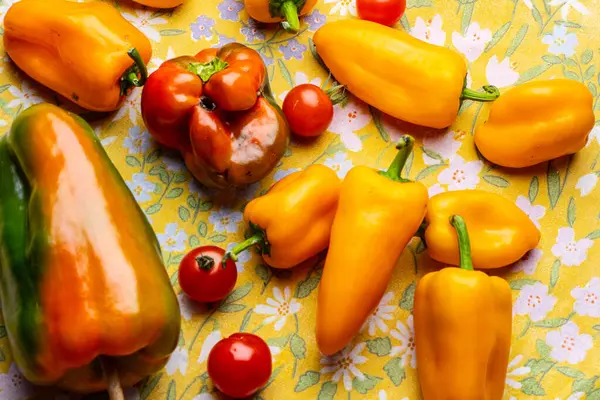 Masada portakal biberi ve olgun kırmızı domates..
