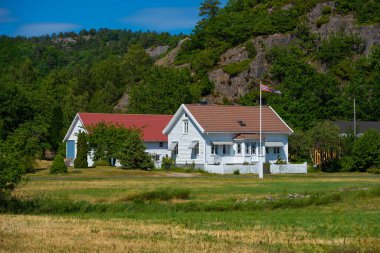 Geleneğe göre küçük bir tepenin yanında beyaz ahşap bir ev.