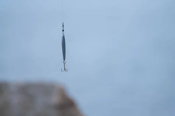 Hook hanging from a fishing line.