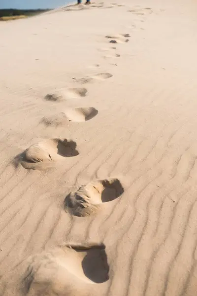 foot tracks in loose desert sand.