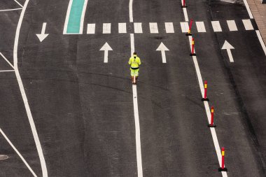 Stromstad, İsveç - 31 Temmuz 2021: İki trafik şeridi arasında beyaz bir çizgi üzerinde duran kişi.