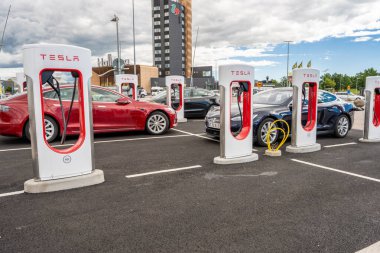 Halmstad, İsveç - 10 Temmuz 2022: Tesla Supercharger Halmstad 'da uzun sıra Tesla arabaları şarj ediliyor.