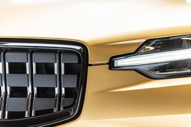 Göteborg, İsveç - Aralık 05 2021: Grille ve altın rengi bir Polestar 1 hibrid arabanın ön ışığı.
