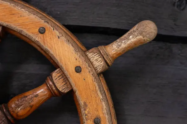 Details of a wooden ship steering wheel.