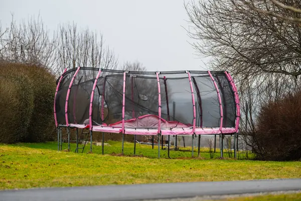 Pink trampoline in a park.
