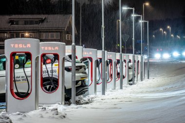 Göteborg, İsveç - 20 Ocak 2024: Geceleri Tesla Supercharger 'da arabalar şarj ediliyor.