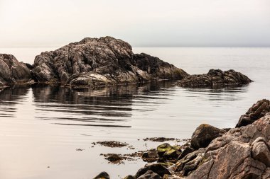 Sakin bir okyanusta dramatik uçurumlar.