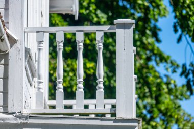 Beyaz bir evin balkonunun ahşap korkulukları..