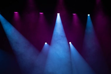 Bir konserde mavi ve mor sahne ışıkları.