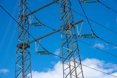 Yüksek voltaj direğinin izolatörleri ve elektrik hatları.