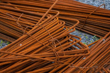 Piles of rusty rebar ready to be used at a construction site.