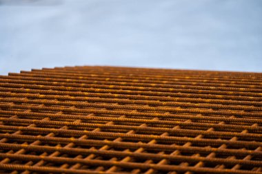 Piles of rusty rebar ready to be used at a construction site.