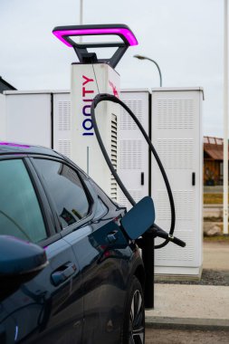 Uppsala, İsveç - 10 Mart 2024: IONITY DC şarj cihazında mavi elektrikli araba.