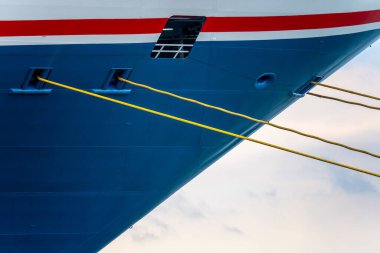 Mavi bir yolcu gemisinin sarı pruva halatları.