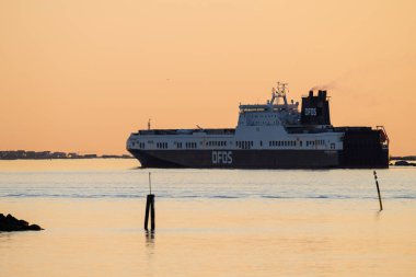 Göteborg, İsveç - 14 Mayıs 2024: DFDS nakliye gemisi akşam güneşinde limandan ayrılıyor.