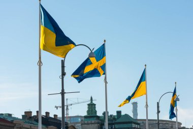 Göteborg, İsveç - 27 Şubat 2022: Gustaf Adolfs Meydanı 'nda düzenlenen bir savaş protestosu sırasında Ukrayna ve İsveç bayrakları yan yana dalgalanıyor.