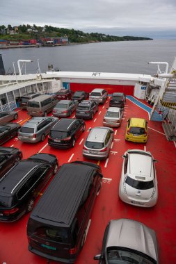 Moss, Norveç - 25 Ağustos 2023: Bir araba feribotunun kırmızı güvertesine park edilmiş arabalar.