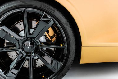 Göteborg, İsveç - Aralık 05 2021: Altın bir Polestar 1 hibrit elektrikli arabanın ön tekerleği ve yan tarafı.