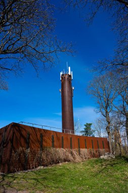 Mobile telephone base tower and district heating funnel.