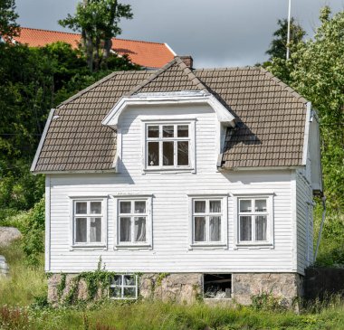 Geleneksel beyaz ahşap ev yamaçta inşa edilmiş..