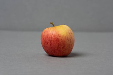 Gri arkaplanda sarı ve kırmızı elma.