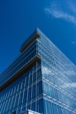 Büyük bir ofis kompleksinin cam cephesine bakıyorum..