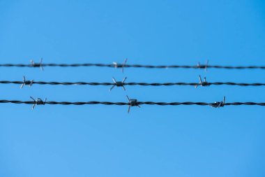 Mavi gökyüzünde üç dikenli tel