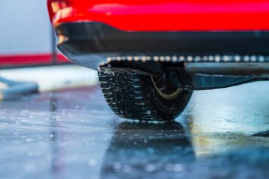 Aracın altında arka tekerlek ve ıslak yüzey