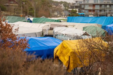 Konut depolama alanında renkli brandalarla kaplı tekneler