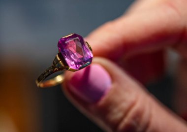 Pembe değerli taşlı altın bir yüzük.