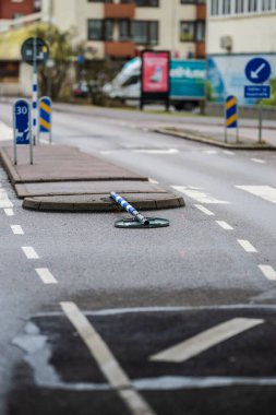 Beyaz şeritli yol ve düşmüş mavi ve beyaz çizgili direk