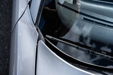 Gri bir spor arabanın ön cam sileceği ve kaputu.