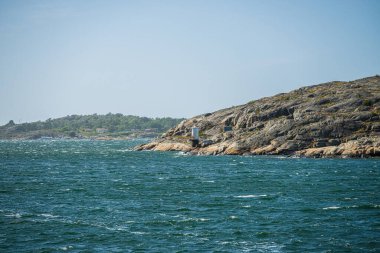 Küçük silindirik deniz feneriyle Rocky kıyı şeridi