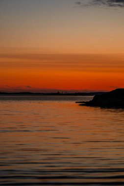 Alacakaranlıkta denizin üzerinde altın ufukta