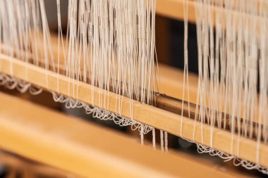 Ahşap dokuma tezgahındaki beyaz iplikleri kapatın.