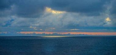 Güneş ışığı bulutların arasından yükseliyor.