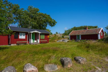 Rüzgarlı otlak tepelerde geleneksel kırmızı kulübeler