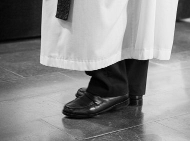 Taş zeminde duran bornozlu papaz.