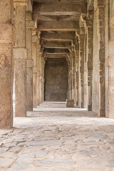 A walkway in the old Indian kutub minar complex. The vintage beams narrating the khalji dynasty history in India
