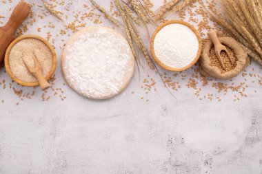 Buğday kulaklı ev yapımı pizza hamuru, buğday unu ve buğday taneleri için malzemeler beyaz beton arka planda..