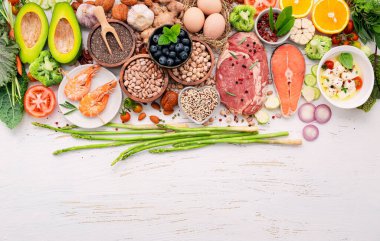 Ketojenik düşük karbonhidrat diyet konsepti. Beyaz ahşap zemin üzerine kurulmuş sağlıklı yiyecekler seçimi için gerekli malzemeler.