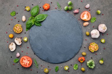 Koyu taştan arka planda ev yapımı pizza malzemeleri..