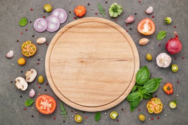 Koyu taştan arka planda ev yapımı pizza malzemeleri..