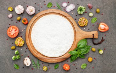 Koyu taştan arka planda ev yapımı pizza malzemeleri..